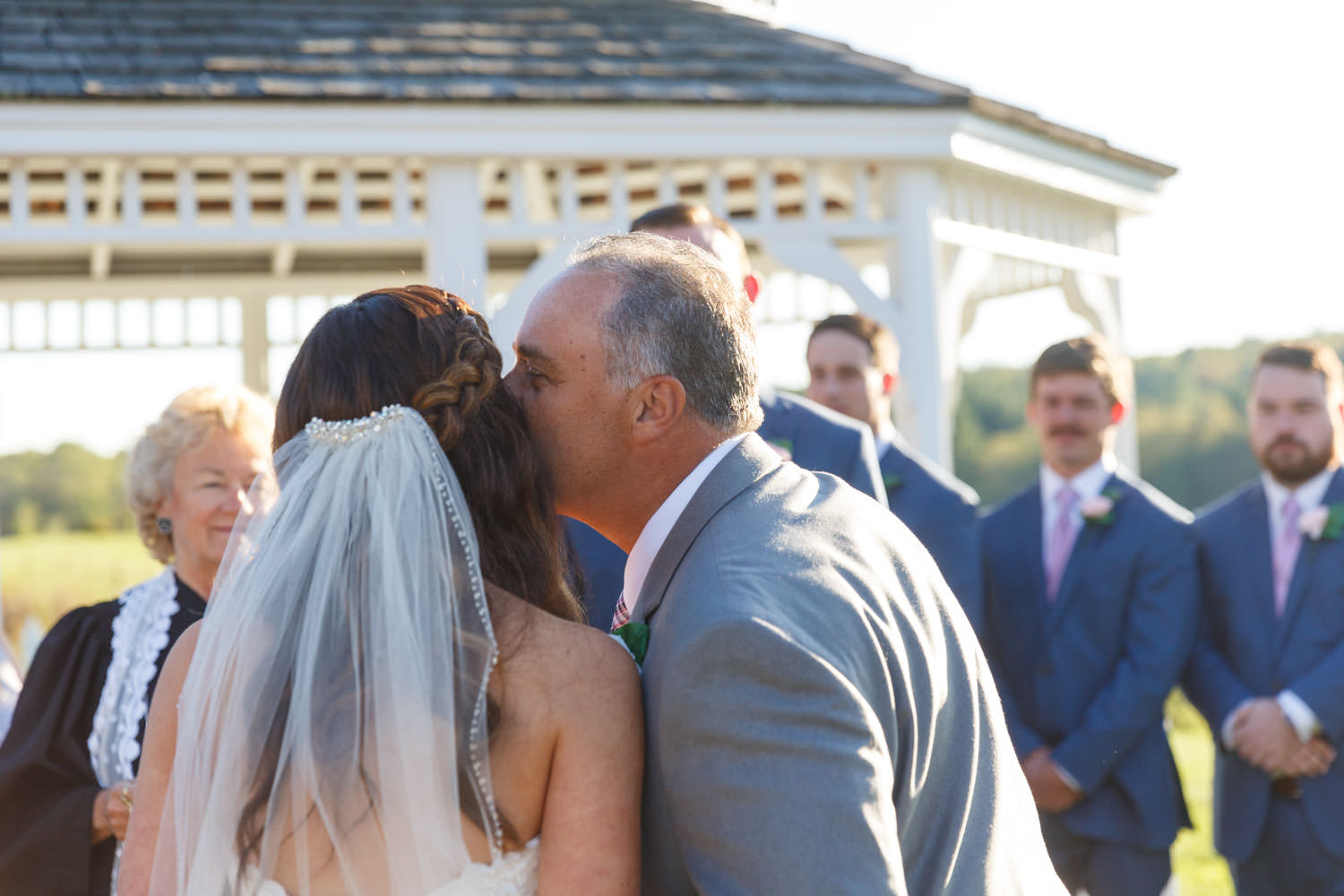 Father of the bride, kissing bride on cheek as he gives her away