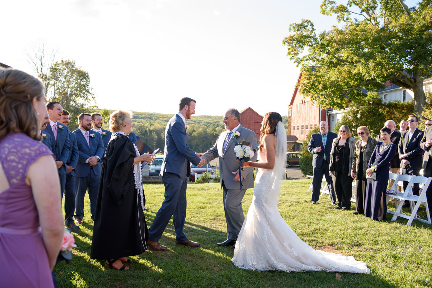 Father of the bride, shaking grooms hand during outdoor ceremony