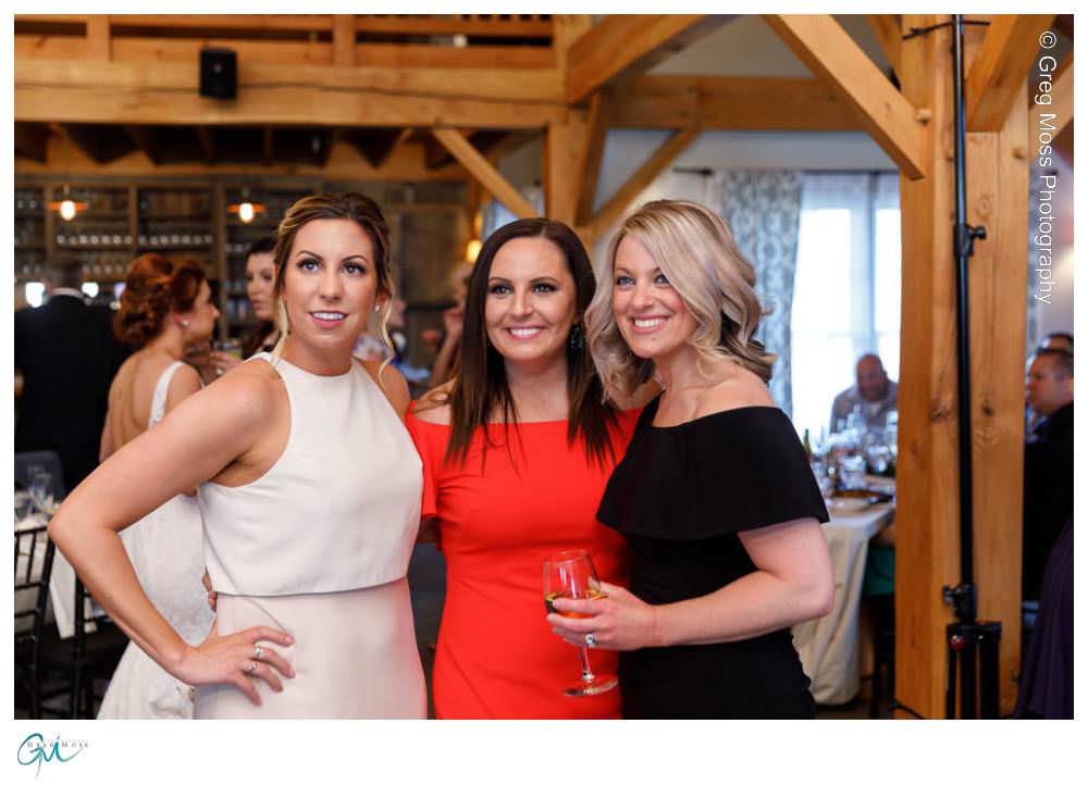 Maid of honor with friends on dance floor in barn
