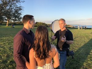 Photographer explaining pose to engaged couple