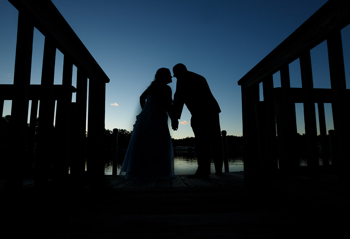 Silhouette of wedding couple on dock at Sturbridge Host Hotel