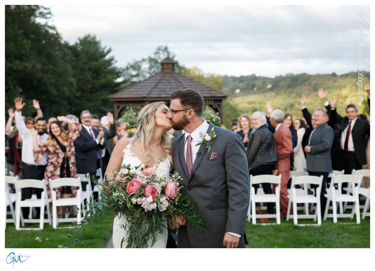 Bride and Groom Kiss with wedding guests in background