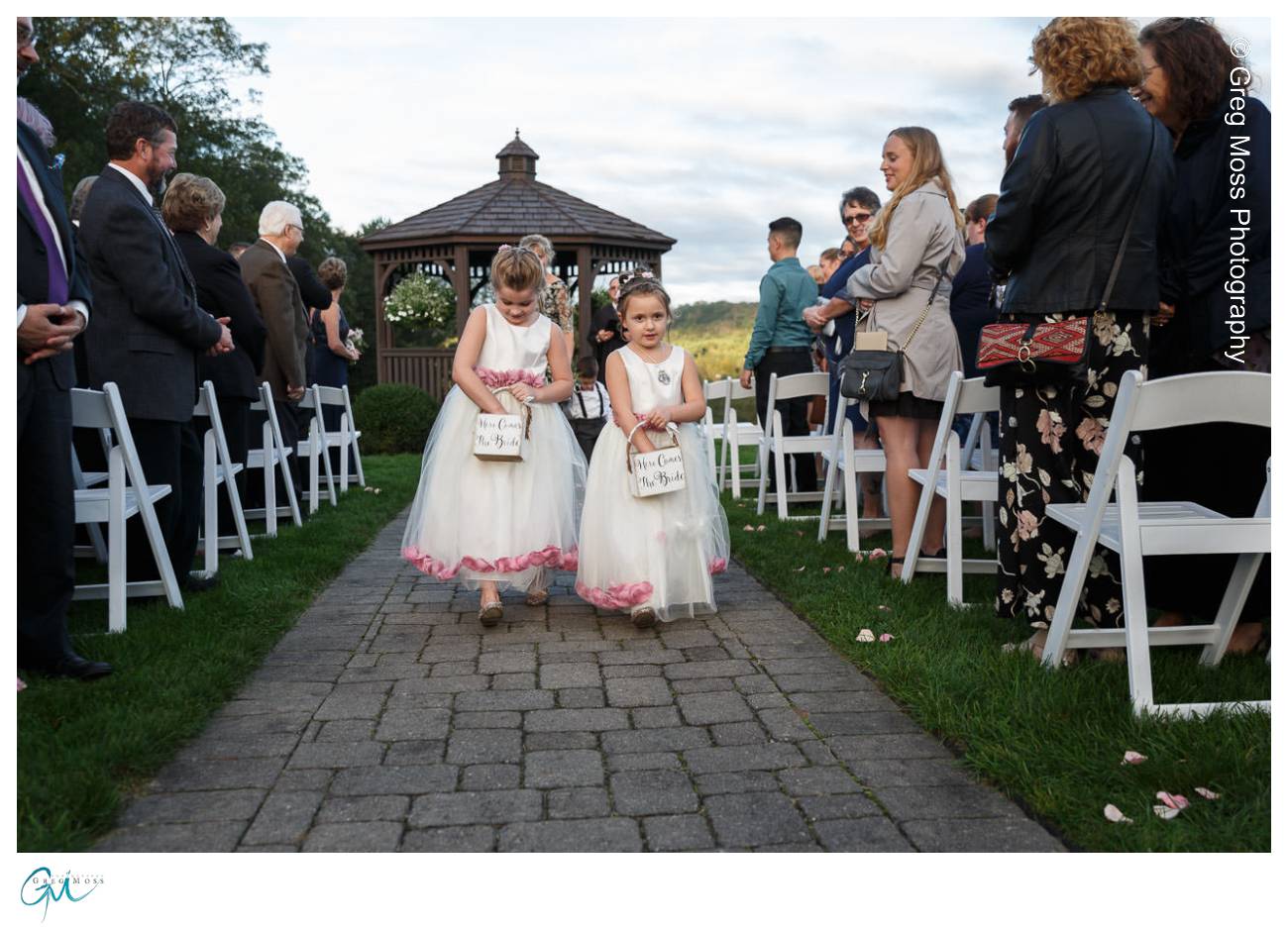 Flower girls throwing flower petals walking down the aisle