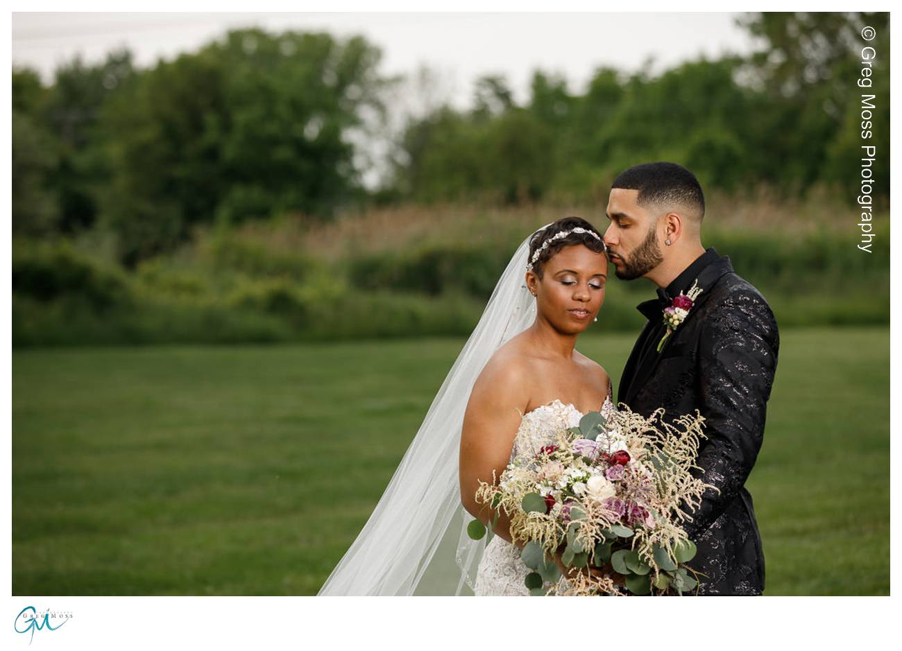 Groom kissing bride on forehead