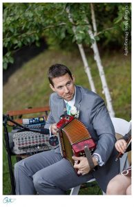 Groom playing according during cocktail hour