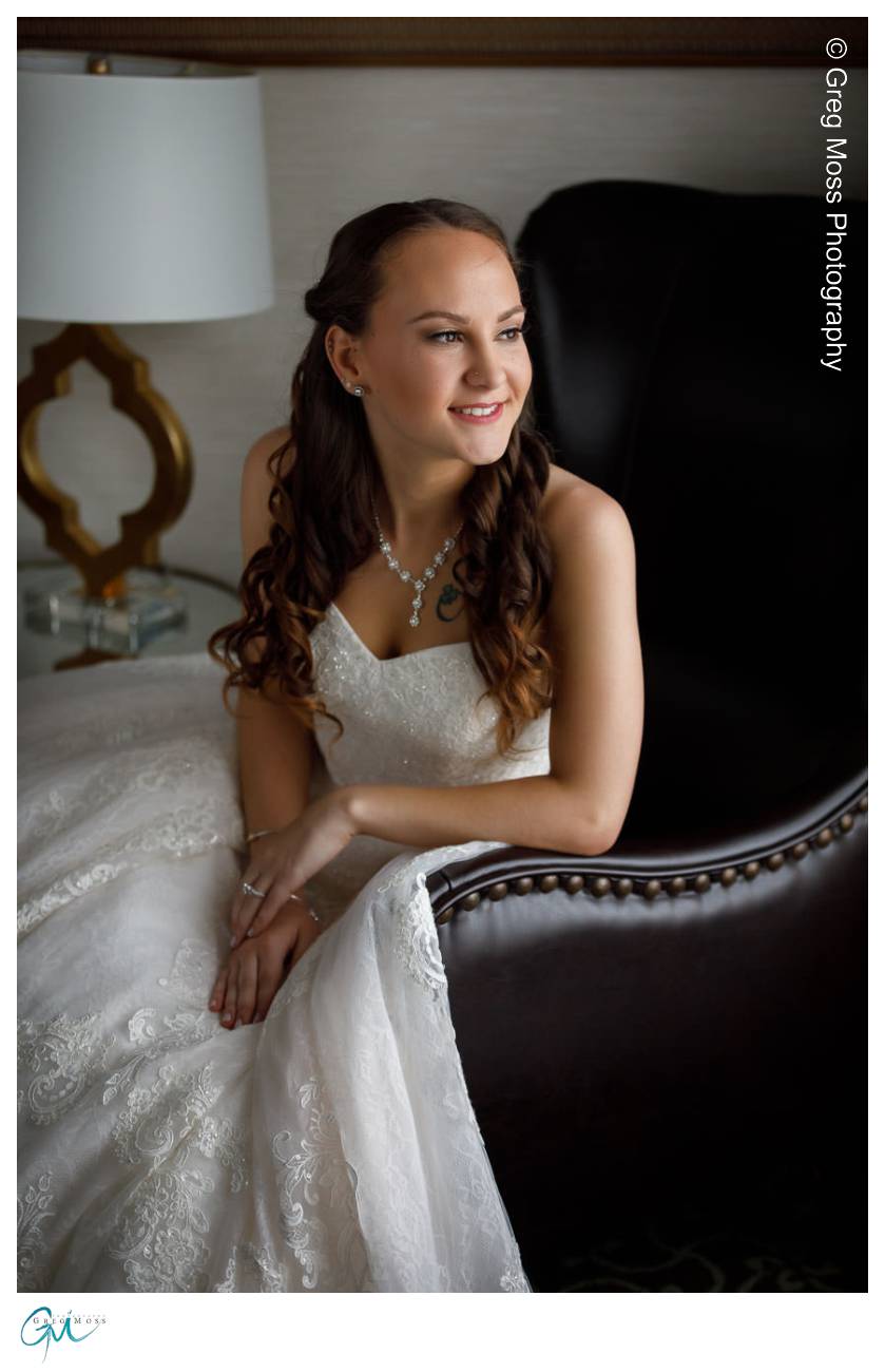 Bride leaning on chair looking out window