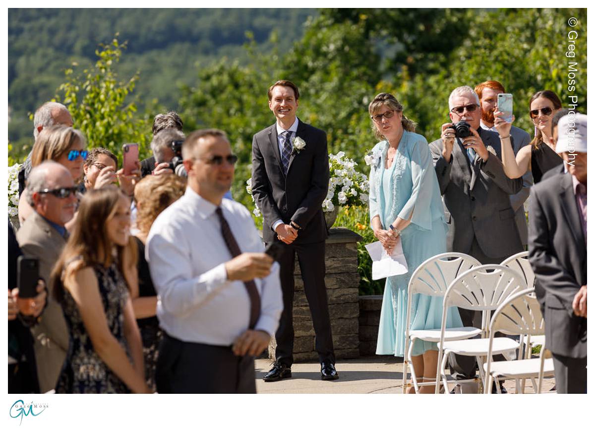 Groom watching as bride walks down the aisle
