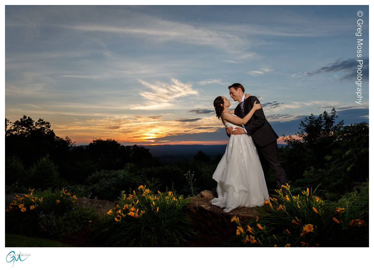 Groom dipping bride at sunset