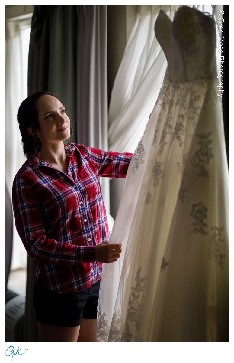 bride looking at wedding dress in window