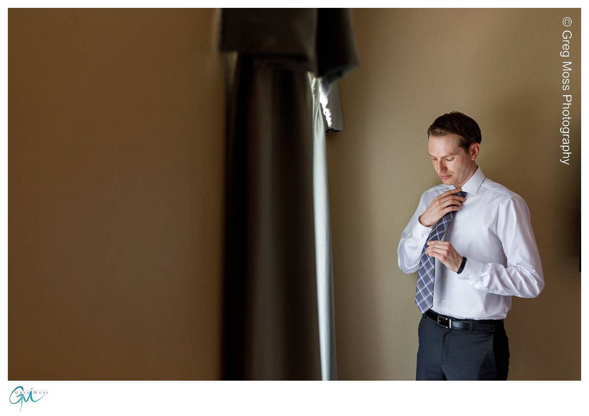 Groom getting ready tying his tie