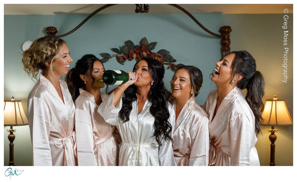 Mountain Rose Inn Wedding-10 Bride drinking champagne out of the bottle with bridesmaids in matching robes