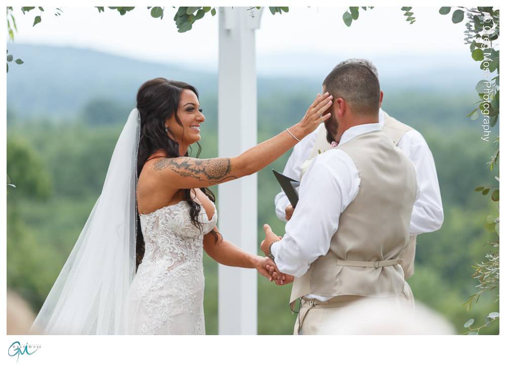 Mountain Rose Inn Wedding-12 Bride wiping tear from grooms face during ceremony