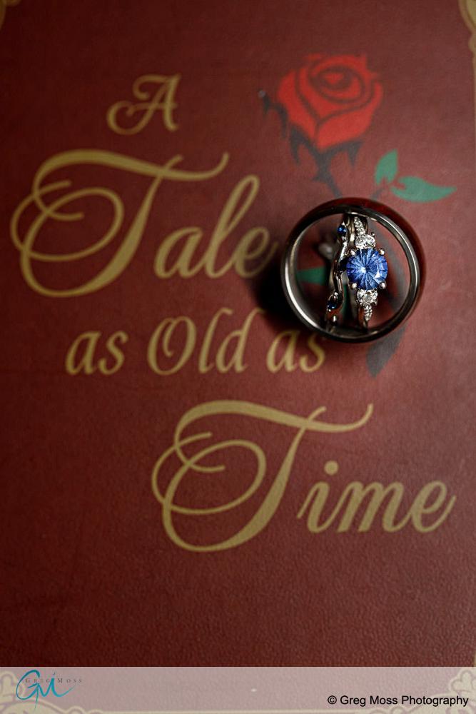 Photo of blue wedding ring on a book called Tale as old as time