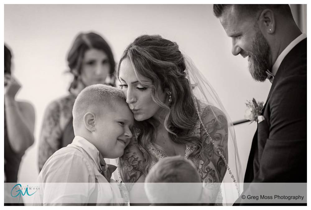 The Boylston Rooms Wedding-12 Bride kissing sun during gift exchange during ceremony