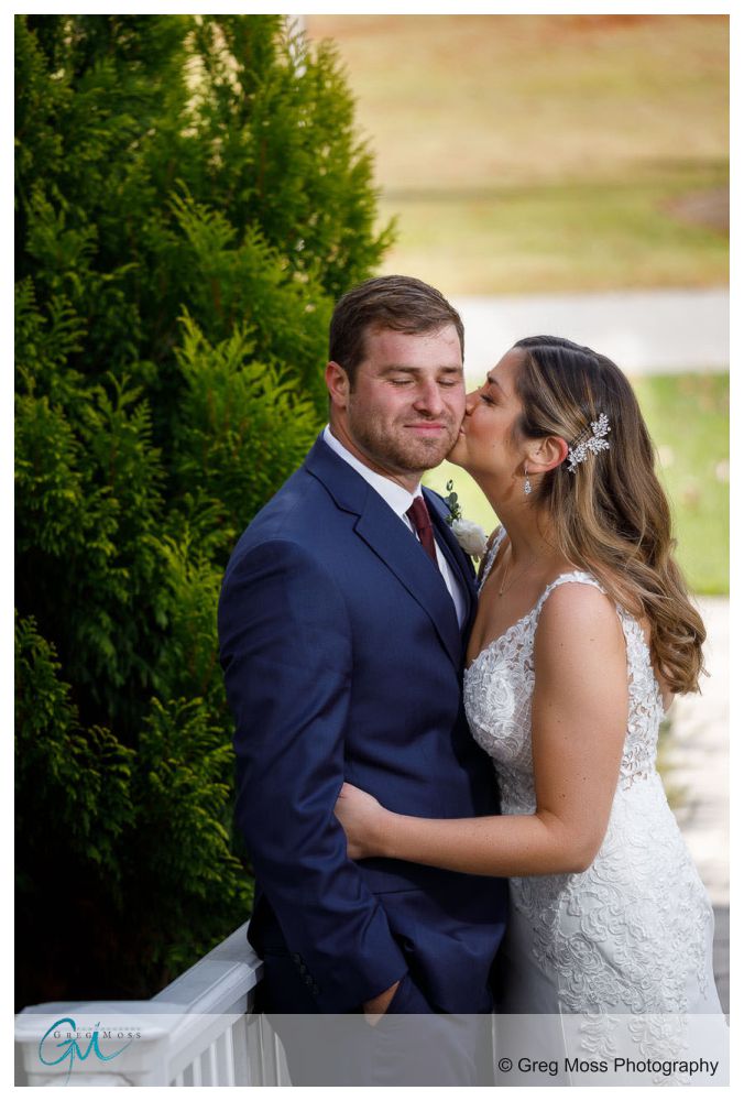 Bride kissing groom on check outside on a cold November wedding day