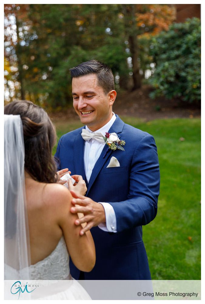 Groom in blue suit holding bride during first look