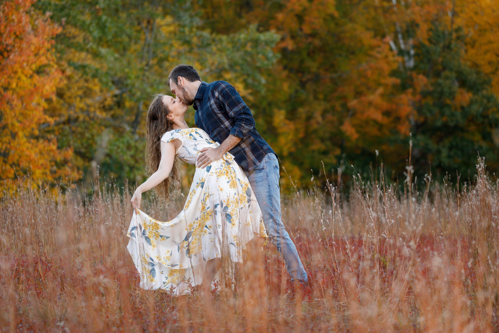 Stunning photo of a couple dipping in hanks meadow Quabbin reservoir with a pretty white and yellow flower dress