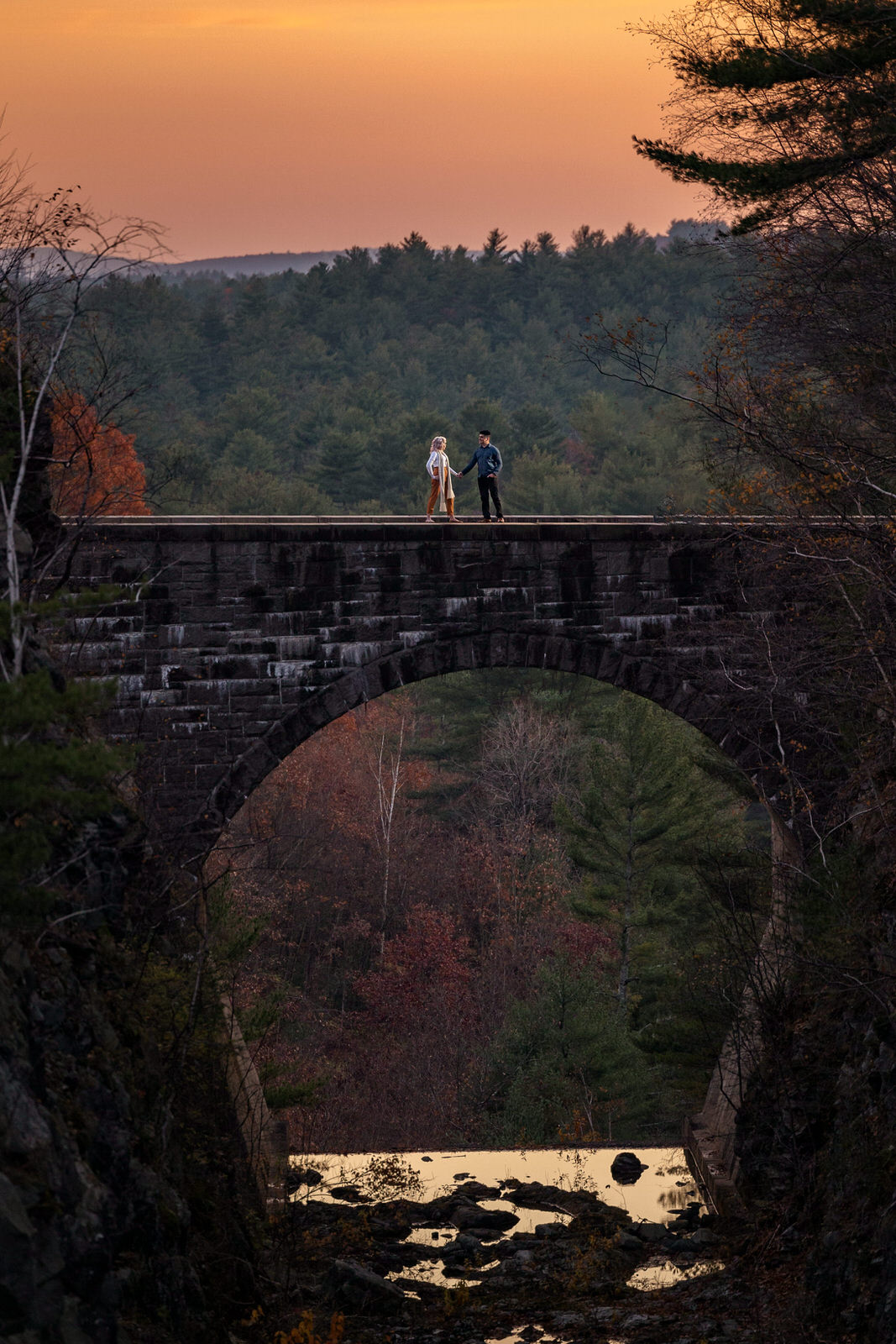 incredible engagement photo on spillway bridge at Quabbin Reservoir