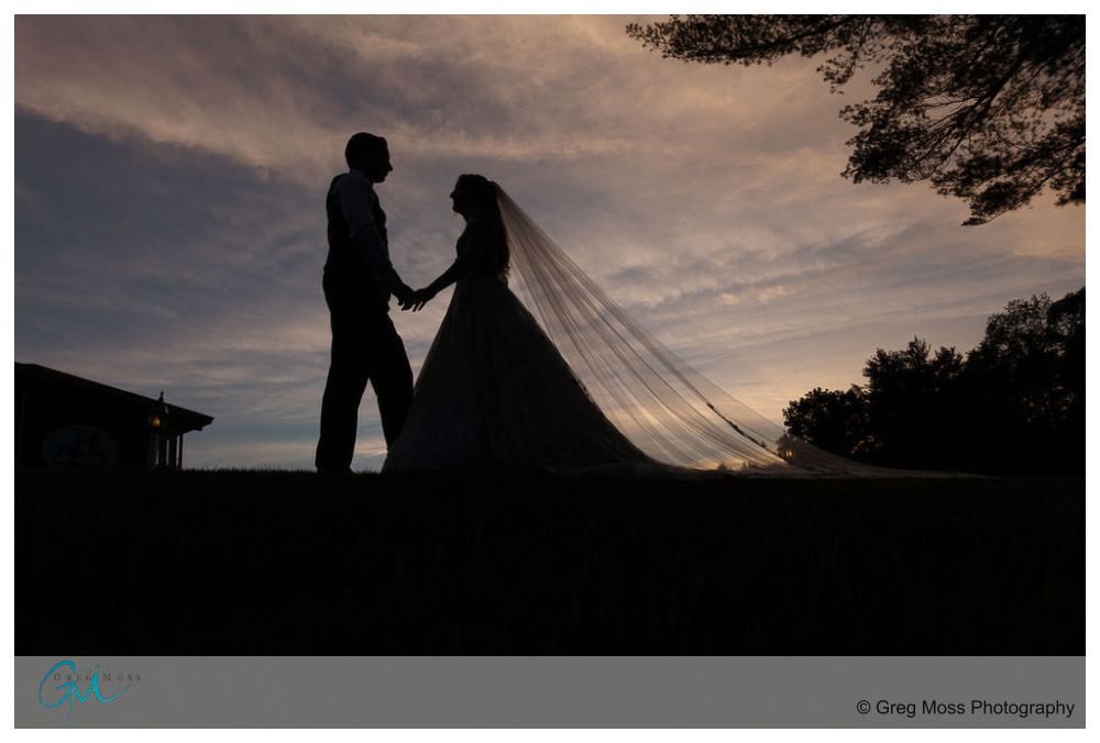 Publick House Wedding-19 Silhouetted couple holding hands, with the bride's long veil flowing, against a twilight sky at a Publick House Wedding.