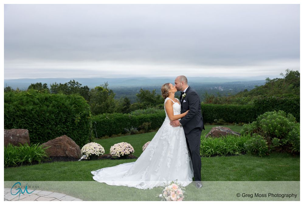 Log Cabin Holyoke Weddings-20 Bride and groom kissing outdoors with expansive hillside view in the background at their Holyoke wedding.
