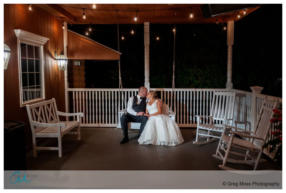 Log Cabin Holyoke Weddings-22 Wedding couple on bench swing in front of the Log Cabin Holyoke
