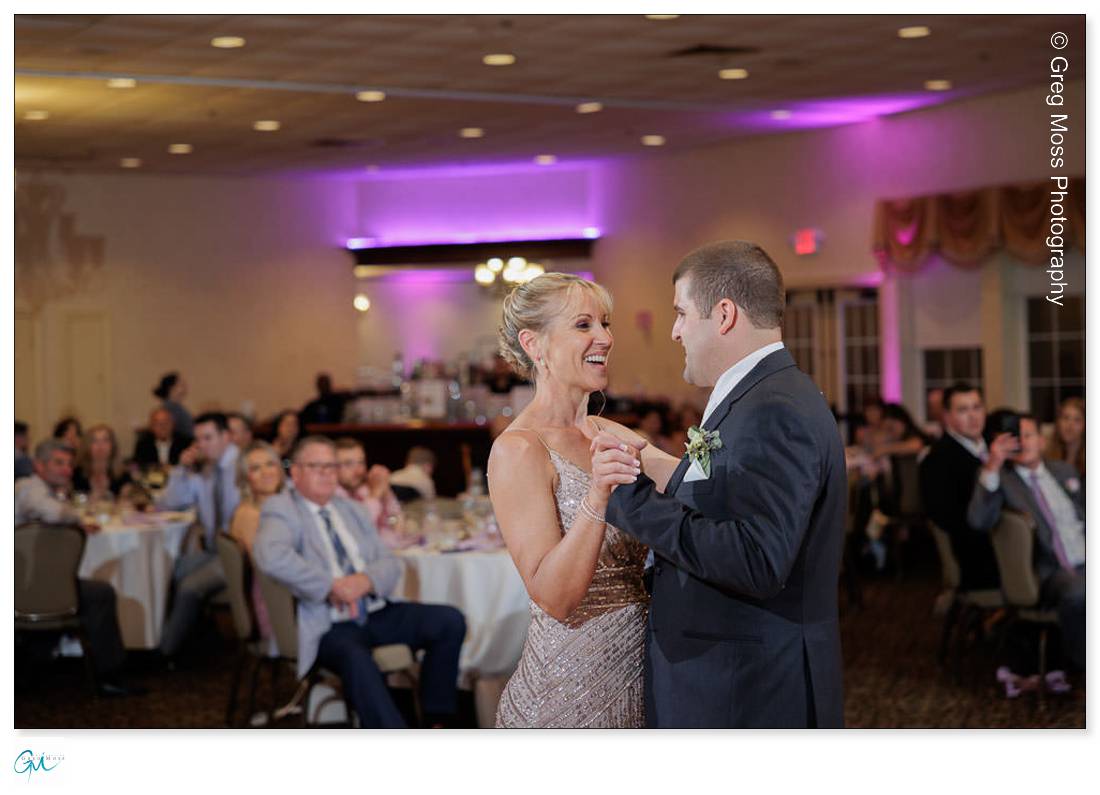 Holyoke Wedding Photography-19 Mother and son sharing a joyful dance at a Holyoke wedding reception, surrounded by seated guests watching them.