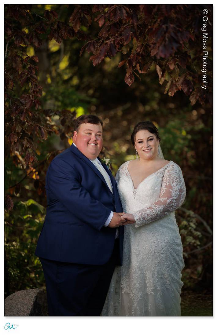 Highfield Hall Wedding-20 A bride and a groom holding hands and smiling under autumn leaves at a Highfield Hall Wedding.
