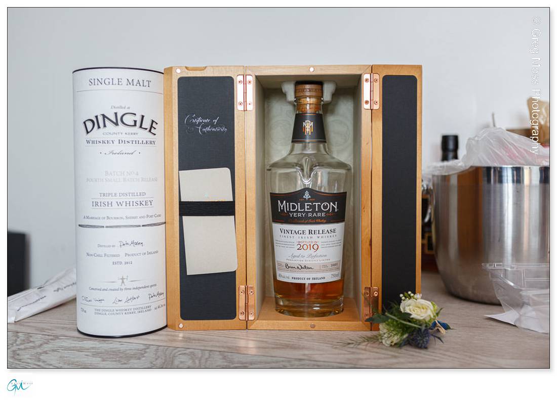 Highfield Hall Wedding-3 A bottle of Midleton Very Rare 2019 Irish whiskey in a Highfield Hall wedding presentation box beside a Dingle whiskey tube on a counter.