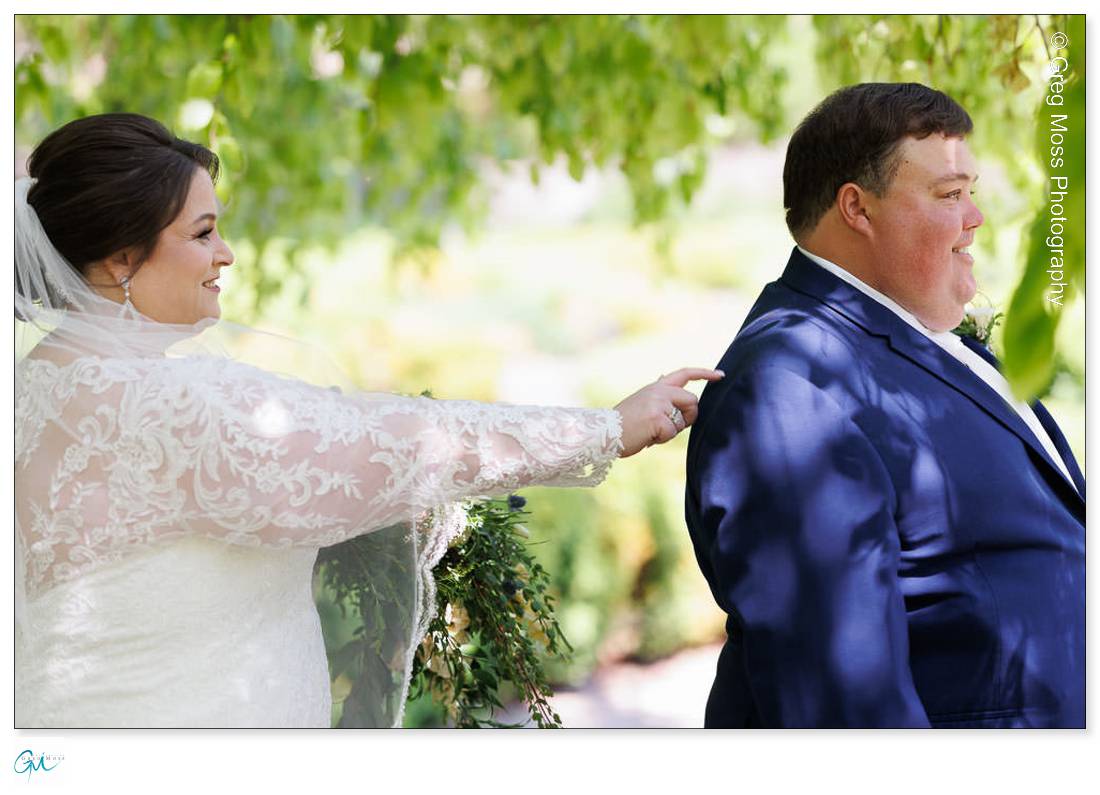Highfield Hall Wedding-8 A bride and groom smiling at each other outdoors at Highfield Hall, the bride touching the groom's shoulder. Both are dressed in wedding attire.