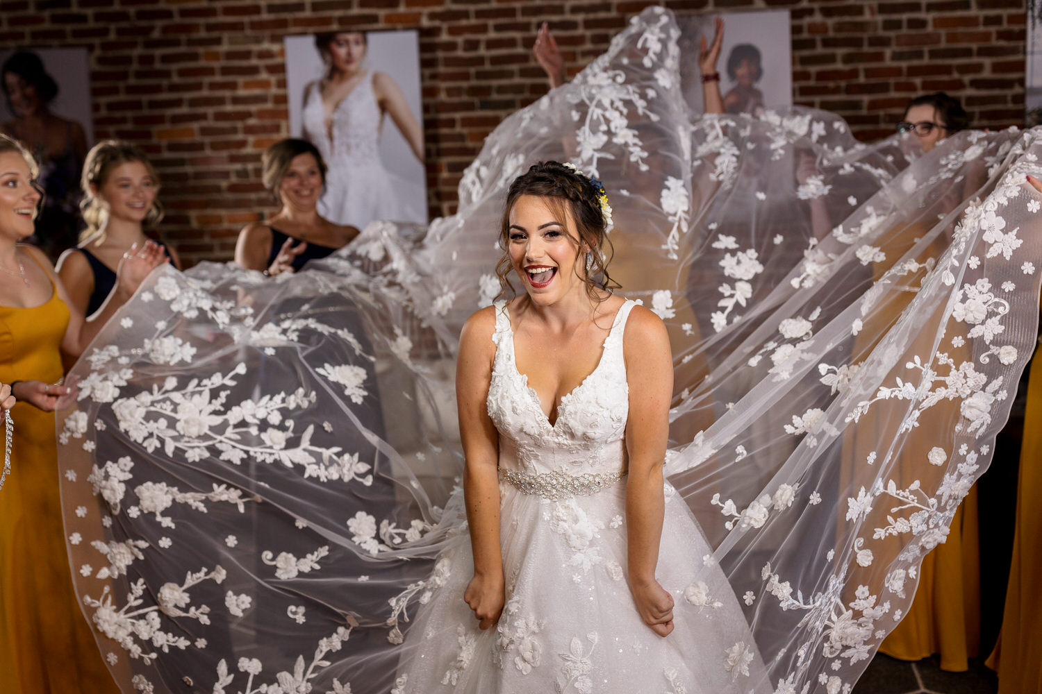 Bridesmaids holding dress up for bride