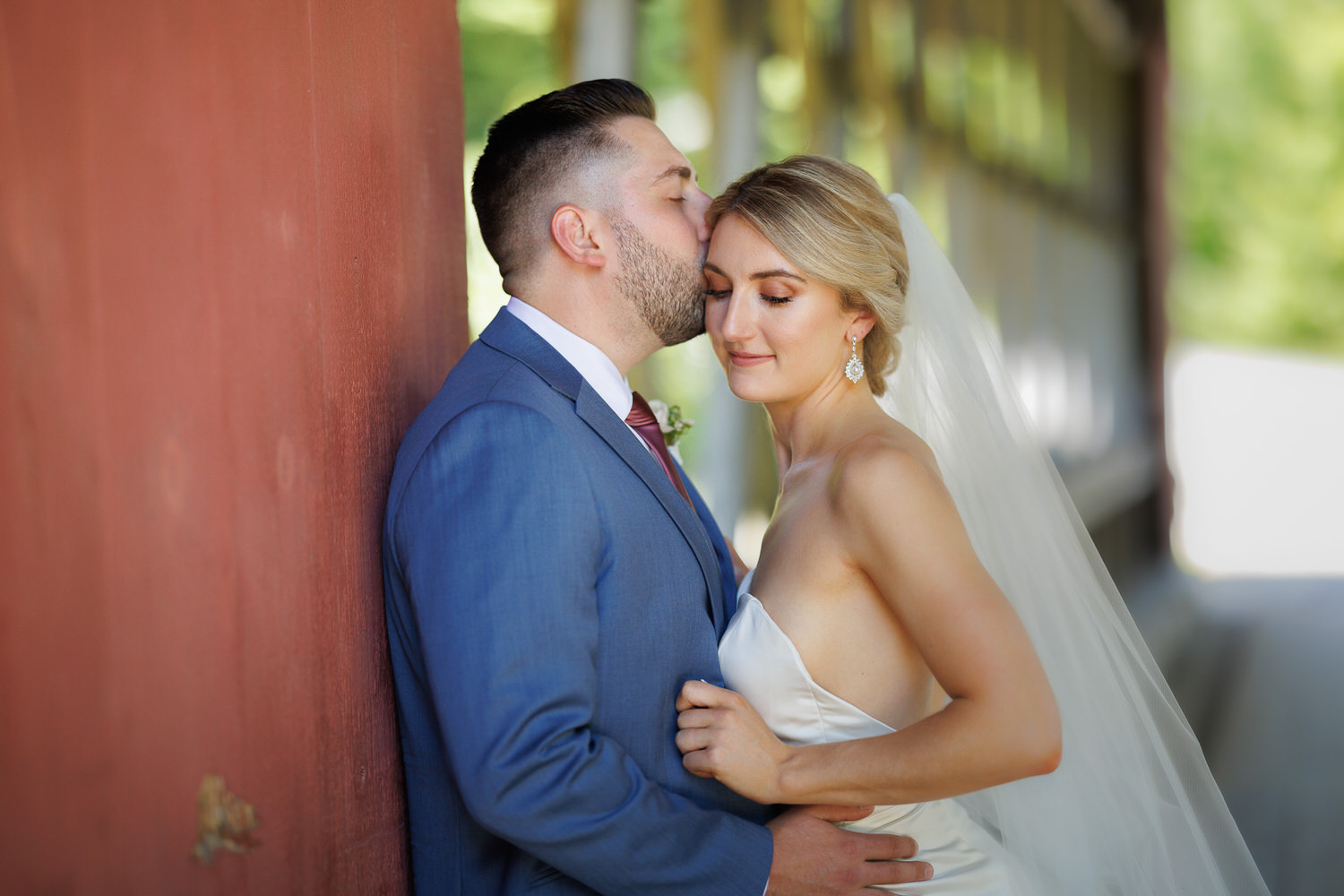 Bride and groom wedding day portrait inside red covered bridge at Stratton Mt.