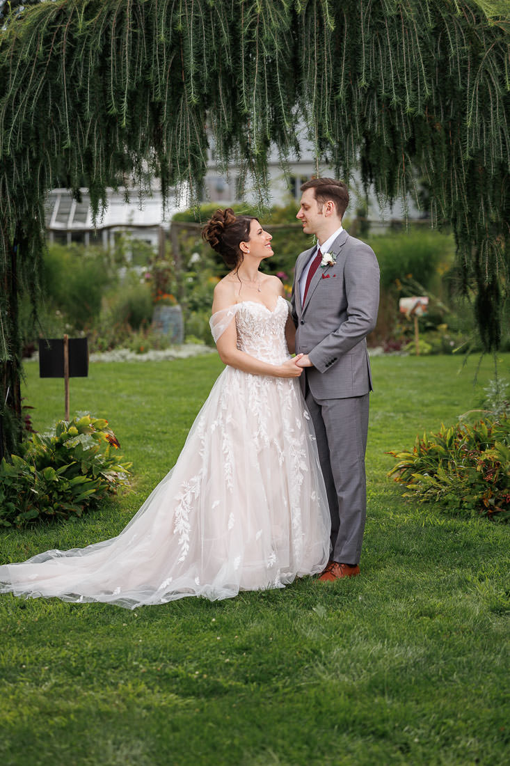 Union Station Wedding-10 A bride in a white gown and a groom in a gray suit holding hands and looking at each other affectionately in Union Station.
